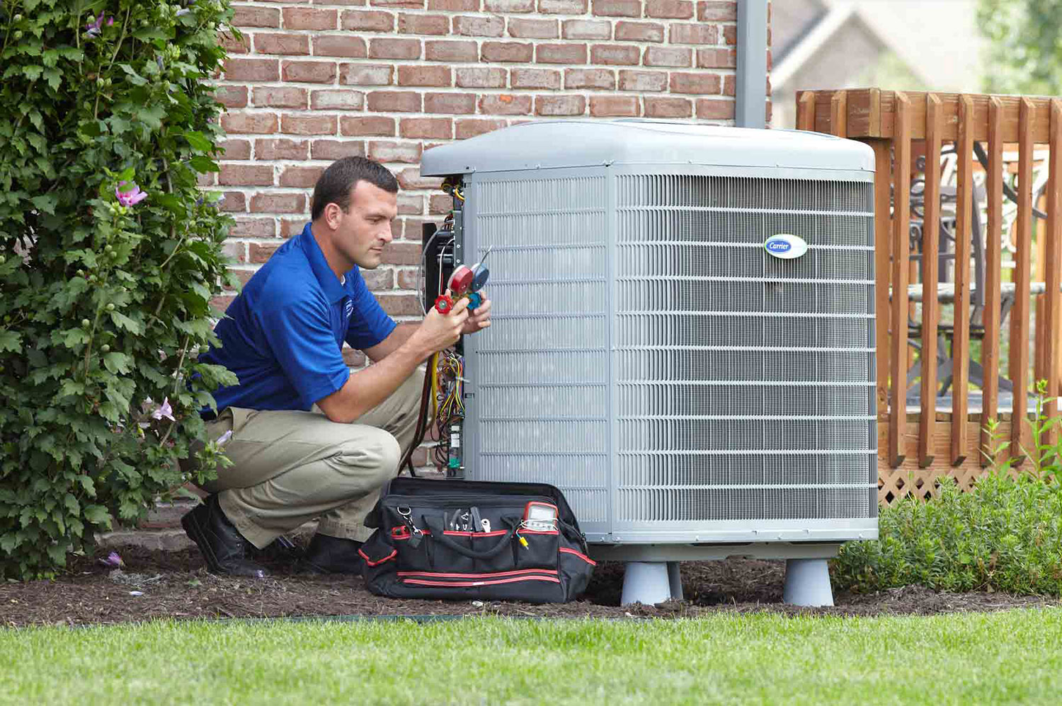 Technician installing Carrier brand air conditioning unit Technician installing Carrier brand air conditioning unit